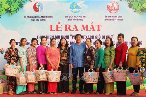 Phụ nữ xách giỏ đi chợ, hạn chế sử dụng túi nilon