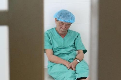 Bác sĩ 62 tuổi ngồi bệt trên sàn nhà, chợp mắt sau ca mổ miễn phí