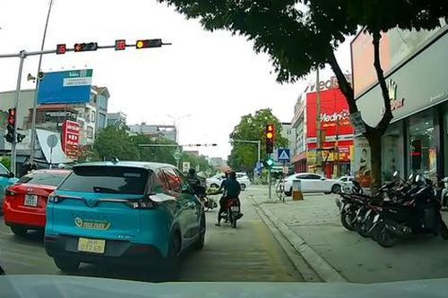Taxi dừng chờ đèn đỏ giữa vạch mắt võng, chặn ô tô rẽ phải