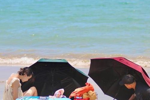 Du khách bịt mặt, che ô tắm biển giữa trưa nắng 40 độ C