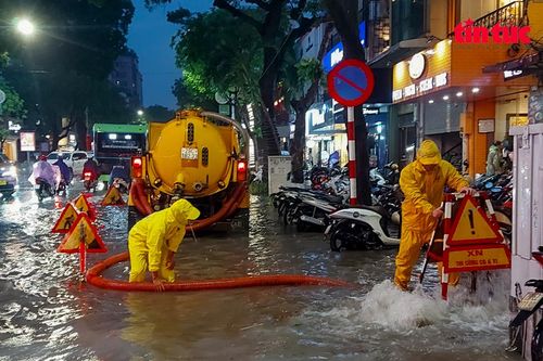 Người dân Hà Nội bì bõm lội nước trong trận mưa lớn