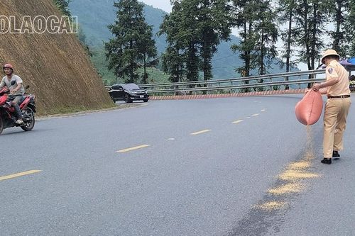 Cảnh sát giao thông rải trấu lên vết dầu loang giúp người dân và du khách tham gia giao thông an toàn