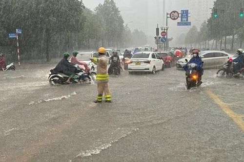 Sau trận mưa lớn, CSGT Hà Nội hướng dẫn người dân vượt ngập úng đến công sở