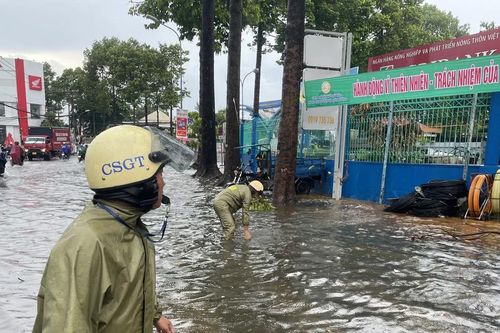 CSGT TP Thủ Đức hỗ trợ người dân di chuyển qua các đoạn ngập nước
