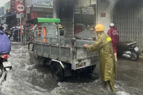 CSGT đội mưa giúp người dân di chuyển qua vùng nước ngập sâu