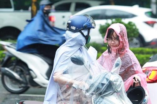 Phụ huynh 'đội mưa' đưa con đi thi môn cuối của kỳ thi lớp 10 công lập Hà Nội