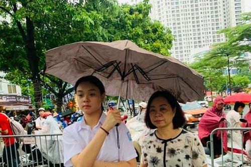 Phụ huynh đội mưa cùng con thi vào lớp 10 ở Hà Nội