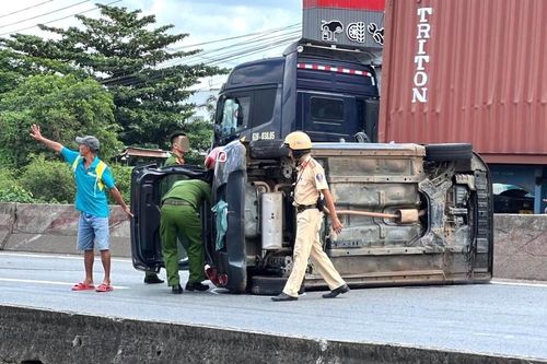 Giải cứu 5 người trong 'xế hộp' lật giữa quốc lộ sau va chạm với xe container