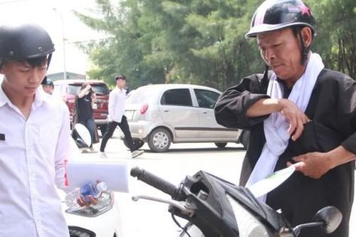 Vợ mất, người cha đeo khăn tang chở con đi thi
