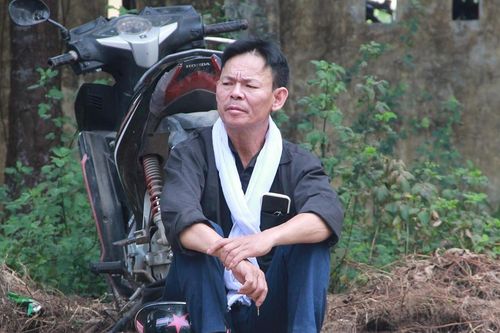 Hình ảnh người cha mặc áo đen, choàng khăn trắng đưa con đi thi tốt nghiệp gây xúc động