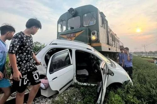 Tàu hỏa 'vò nát' xe con trên đường sắt, người dân tức tốc cứu 2 cha con gặp nạn