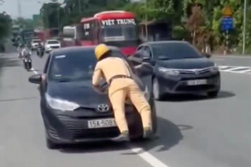 Cảnh sát giao thông nằm trên nắp capo, tài xế vẫn nhấn ga lao vun vút