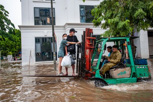 Người dân Thủ đô 'cưỡi' xe nâng vượt biển nước đi làm sau bão số 2