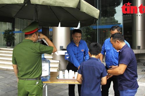 Thanh niên TTXVN hỗ trợ thông tin và nước uống cho người dân đến viếng Tổng Bí thư