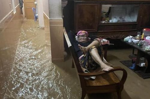 Bức ảnh cụ bà thư thả giữa biển nước trong đêm mưa lũ 'gây bão' mạng xã hội