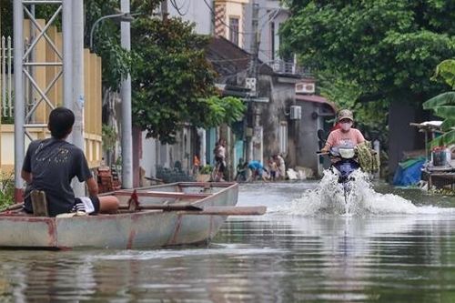 Người dân xóm Bến Vôi đi thuyền trên đường làng