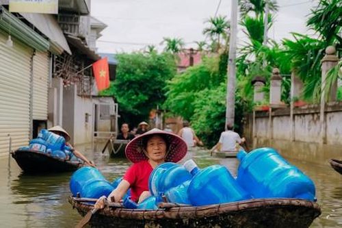 Người dân vùng lũ Chương Mỹ chèo thuyền nhận đồ hỗ trợ