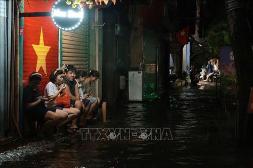 Hà Nội: Người dân ngồi trú mưa, chờ nước ngập rút trên phố Nguyễn Du