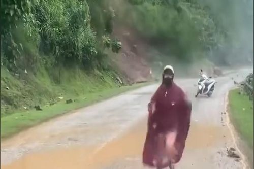 Người phụ nữ bỏ xe máy chạy khi đất đá lở từ trên núi xuống