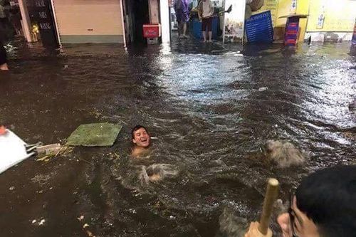 Du khách nước ngoài 'chill' trong nước mưa ngập phố cổ