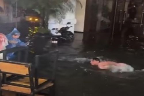 Du khách nước ngoài thích thú bơi lội ngay trên phố cổ Hà Nội sau cơn mưa lớn