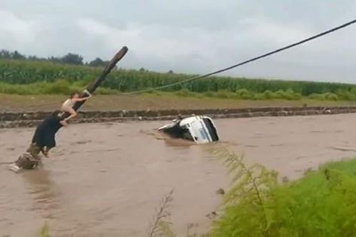 Ôtô bị cuốn trôi xuống sông, 2 mẹ con nhanh trí trèo lên cột điện