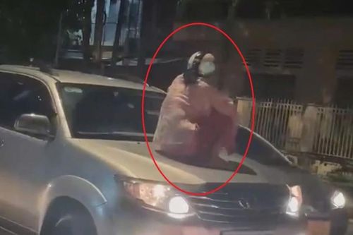Cận cảnh người phụ nữ ngồi trên nắp capo ôtô ở Bình Dương