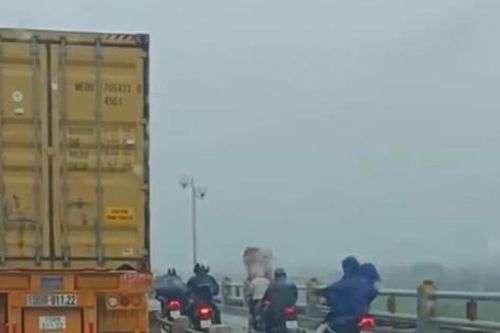 Xúc động hình ảnh lái xe che chắn gió bão cho người dân trên đường trong bão