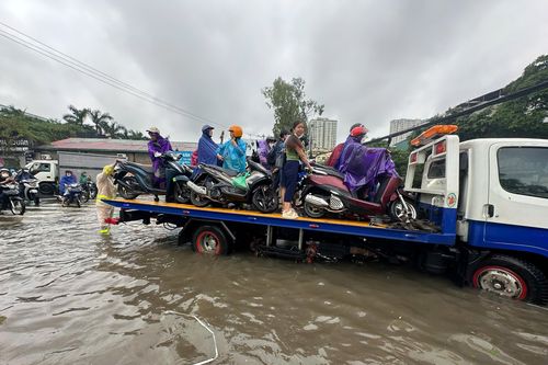 CSGT dầm mưa dùng xe cẩu đưa người dân qua đoạn đường ngập sâu