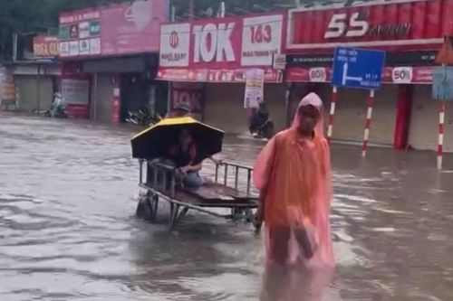 Đường vào nhà ngập hơn nửa mét, phụ huynh thuê xe kéo đón con đi học về