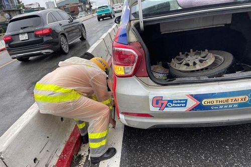Hình ảnh đẹp về Đại úy CSGT hỗ trợ thay lốp cho xe taxi trong ngày mưa