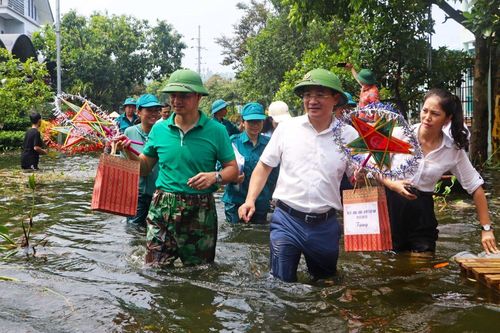 Nghệ sĩ Xuân Bắc và Tự Long chống thuyền, lội nước trao quà Trung thu cho trẻ em