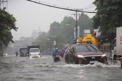 TP Hồ Chí Minh: Người dân vất vả di chuyển khi triều cường và mưa cùng lúc