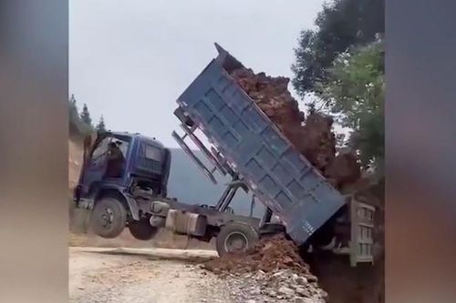 Khoảnh khắc xe ben đang đổ đất bị nhấc bổng rồi lăn xuống vực