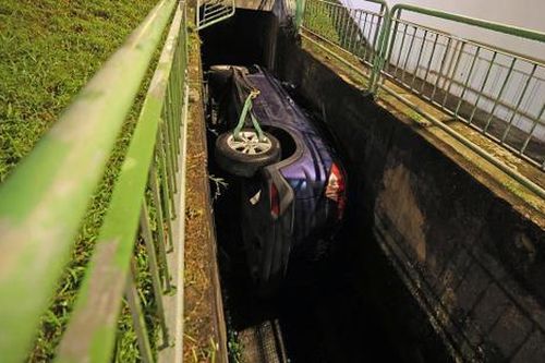 Va chạm với xe buýt trên đường, chiếc ô tô nằm lật ngang dưới kênh