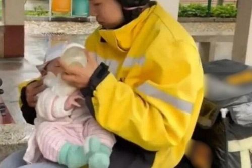 Cảnh nữ shipper trẻ vừa ăn vội bữa trưa vừa cho con sơ sinh bú giữa trời mưa gió làm ai cũng thấy thương