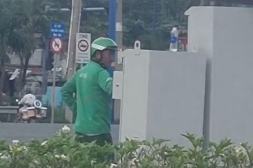 Người mặc đồ GrabBike chỉnh tín hiệu đèn giao thông ở TP.HCM