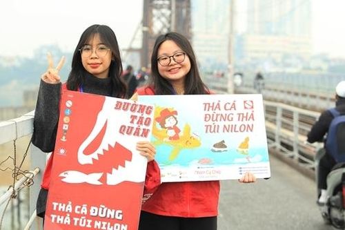 Tình nguyện viên vận động người dân thả cá không vứt bỏ túi nilon