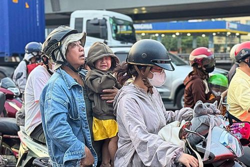 Người lớn và trẻ nhỏ kiên nhẫn vượt ùn tắc ở cửa ngõ TPHCM trong ngày 25 Tết