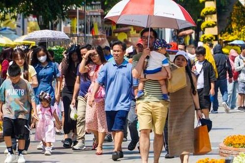 Nắng oi bức, người dân vẫn tranh thủ 'check-in' đường hoa Nguyễn Huệ ngày cuối