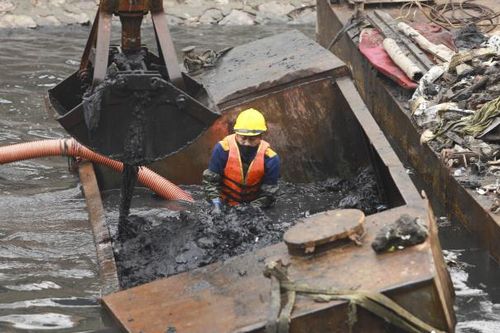 Công nhân ngâm mình dưới dòng nước đen, nạo vét sông Tô Lịch