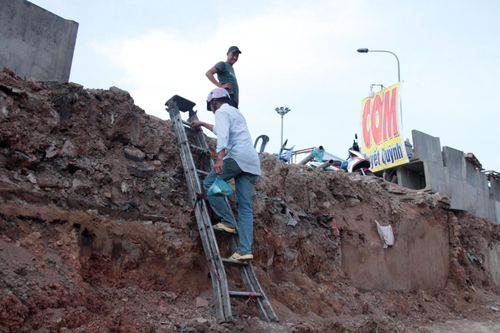 Người dân bắc thang cao 2m để vào nhà tại khu vực thi công nút giao Tân Vạn