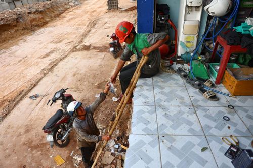 Người dân bắc thang vào nhà tại công trường Vành đai 3 TP.HCM