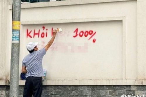 Người đàn ông xịt sơn quảng cáo lên tường ở TP.Vinh