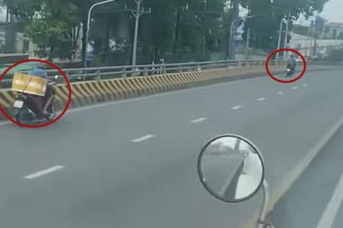 Nhiều xe máy nối đuôi nhau chạy ngược chiều trên cầu vượt ở Bình Dương