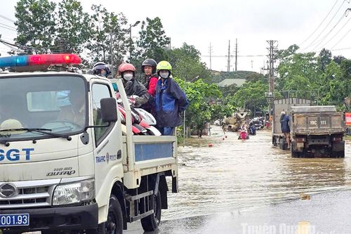 Công an hỗ trợ dọn dẹp đường, chở người dân qua điểm ngập úng trên địa bàn huyện Hàm Yên