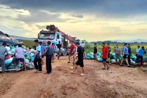 Người dân giúp tài xế bốc xếp bao tải hàng sau tai nạn lật nghiêng bên cao tốc