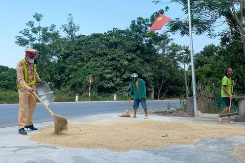 Hình ảnh đẹp Cảnh sát Giao thông Nghệ An giúp dân dọn lúa chạy mưa