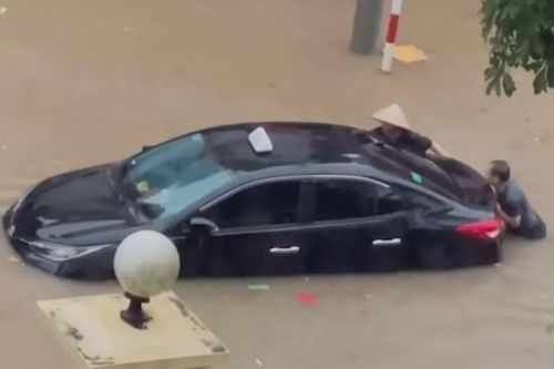 Người dân bì bõm đẩy ôtô ngập trong biển nước sau mưa lớn