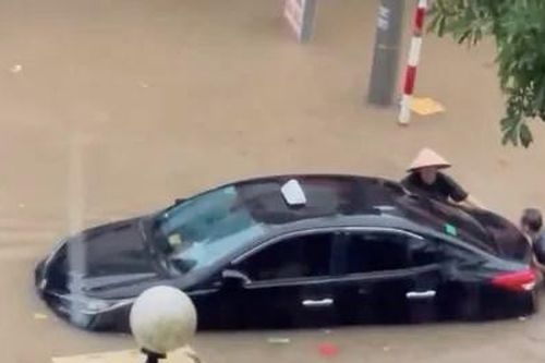 Người dân bì bõm đẩy ô tô ngập trong biển nước sau mưa lớn